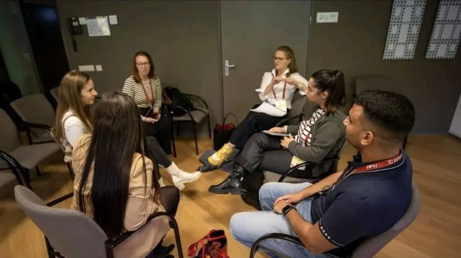 A group session, chairs in a circle, mid-discussion